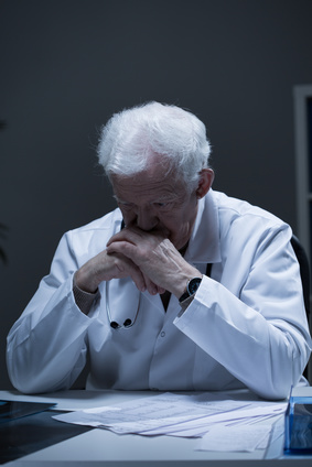 Aged male doctor thinking about medical problem